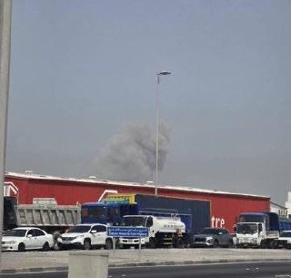 a fire is seen in the distance of a shopping center in the city of abu